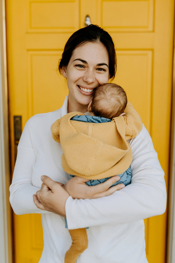 Une maman avec son bébé, avec porte jaune derrière
